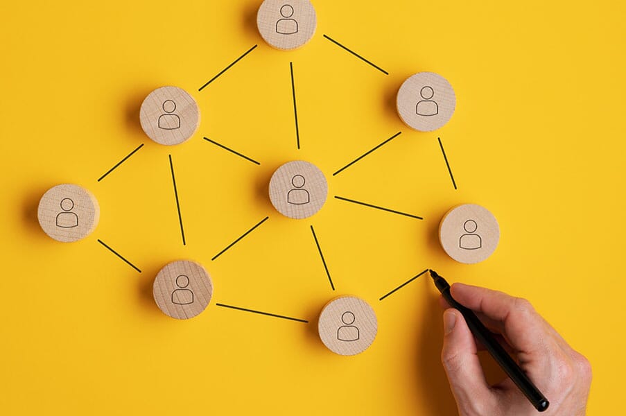 Resopath. Several wooden tiles with an icon of a person lay on a yellow surface. There are drawn black lines connecting them,